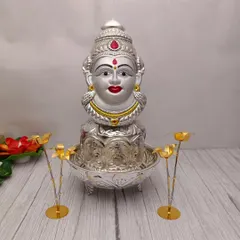 A full pooja setup featuring my German silver Lakshmi face on a pot, placed in an urli, and flanked by two sugarcane trees. This is how you can create a divine look for your festival.
