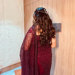 A cascade of soft, romantic curls. This half-up, half-down hairstyle is a classic choice for engagements and receptions, beautifully decorated with a delicate hair accessory.