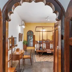 A view into the Arundati suite through its grand, arched wooden doorway, giving a glimpse of the classic elegance that lies within.