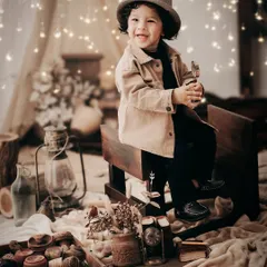 A rustic, camp-themed setup complete with a lantern, wooden toys, and fairy lights. This warm, cozy setting is perfect for capturing the adventurous spirit of a young child.