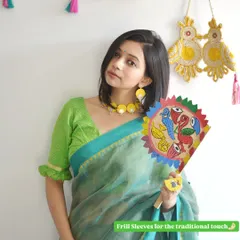 Adding frill sleeves to a simple blouse gives it a traditional and feminine touch. This green blouse with frill details is the perfect companion to a classic cotton or linen saree.