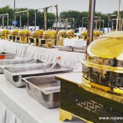 An outdoor buffet setup ready for a large corporate event. The line of polished brass chafing dishes shows my capacity to handle catering for hundreds of guests efficiently.