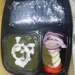 Enjoy a classic North Indian favorite with my Palak Paneer tiffin. The fresh spinach gravy is paired with soft paneer cubes and served with hot rotis and salad for a nutritious meal.