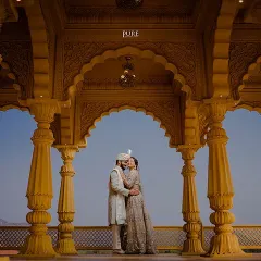 We bring royal dreams to life with shoots set against majestic architecture. This portrait, framed by grand Rajasthani-style arches, captures the elegance and grandeur of a timeless love story.
