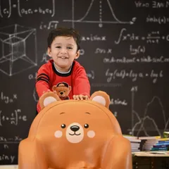 A joyful, candid moment from the 'little genius' shoot, capturing a huge, happy smile.