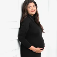 A simple, elegant solo portrait in a classic black dress. This timeless look emphasizes the beautiful silhouette of pregnancy with clean, minimal styling.