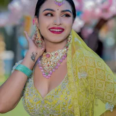 A candid, happy shot of a bride in a bright yellow lehenga, perfect for a Haldi or Sangeet ceremony.