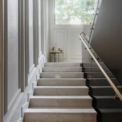 We designed this stairwell to feel like a silent sculpture. The clean marble treads, detailed wall paneling, and soft light from the high window create a serene and structured ascent. The landing is intentionally minimal, offering a moment of pause.