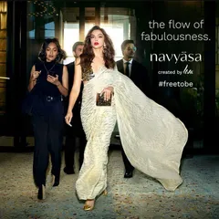 Styling for the Navyasa by Liva campaign featuring Deepika Padukone. The main model's flowing, modern saree is contrasted with the sharp, dark outfits of the background models to create a dynamic and glamorous entrance.