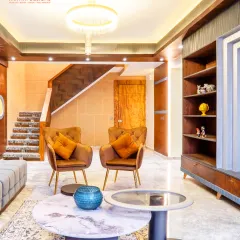 From this angle, you can see the flow from the seating area to the staircase. We used consistent materials and lighting to ensure the entire space feels connected and harmonious.