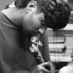 A black and white shot of one of our artists focused on his work. We are dedicated to the art and craft of tattooing.