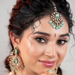 A perfect portrait of modern elegance. The makeup is flawless and radiant, letting the bride's natural beauty shine through while complementing her unique jewelry.