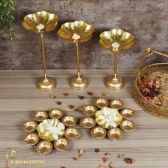 This image showcases our versatile range of brass festive decor, including tall flower-shaped diya stands and multi-diya plates. These pieces can be arranged together to create a grand, layered light display for any celebration.