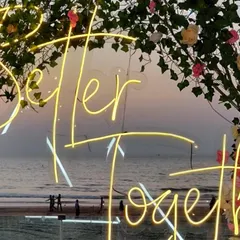 A close-up of the "Better Together" neon sign we used for an engagement party. Set against a floral arch with the sunset in the background, it creates a perfectly romantic photo opportunity.