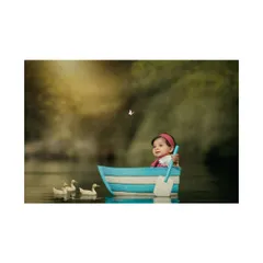 A tiny sailor on a grand adventure. This creative composite photo places a baby in a boat on a calm lake, complete with little ducklings following along.