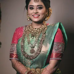 This look balances tradition with a unique color palette. The combination of a sea green saree with a vibrant pink blouse and coordinated jewelry creates a memorable and elegant bridal style.