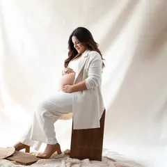A chic and modern look with an all-white outfit against a soft, neutral backdrop. This style is perfect for creating a bright, airy, and sophisticated maternity portrait.