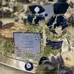 This unique baby announcement hamper is designed around the protective Evil Eye theme. It features a personalized announcement card, silver-plated bowls with navy blue pouches, and the traditional nazar symbol to bestow blessings and ward off negativity.