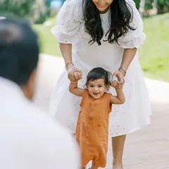 A mother helping her little one take those wobbly first steps. A beautiful moment of support and encouragement captured during an outdoor family session.