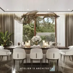 In this farmhouse dining room, a fluidic Italian metal and glass chandelier hangs above a veneer-top table with a fluted leather base. We used bronze Armani marble for the flooring and surrounded the space with beige Italian chairs to create a warm, opulent setting for gatherings.