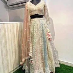 This pastel rainbow lehenga is a beautiful choice for a day wedding or engagement. It features delicate full-sleeve embroidery, mirror work, and a soft, multi-tonal skirt, complete with charming tassels for a touch of playfulness.