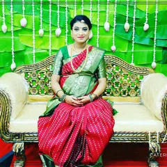 A beautiful portrait of a mother-to-be at her baby shower. The backdrop of green banana leaves and white floral strings provides a fresh and traditional setting.