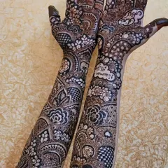 This is a full bridal design that goes all the way up the arms, combining bold floral motifs with delicate, intricate patterns. I also included the names Nauman and Shifa in the palms to make it a unique part of their story.