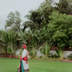 A portrait of the groom in his traditional Maharashtrian wedding attire, complete with a colorful pheta and shawl, standing proudly before the ceremony.
