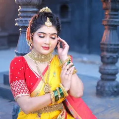 A classic Maharashtrian bridal look. The bright yellow Navuari saree is draped in the traditional style, complete with a nath and green bangles.