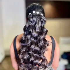 A chic and modern ponytail with voluminous curls and pearl accessories. This hairstyle is perfect for a glamorous cocktail party or reception.