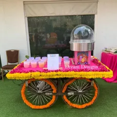 A fun and whimsical addition to a Mehndi celebration. This traditional cart, decorated with marigold and fuschia flowers, serves cotton candy, adding a playful and sweet touch for guests.