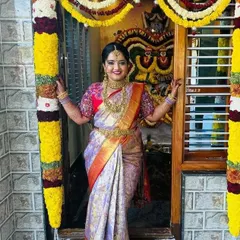 There is nothing more rewarding than seeing a client's joyous smile. This beautiful bride is celebrating in her custom-stitched Kanchipuram silk saree and a blouse with dense, multi-colored floral embroidery on the sleeves.