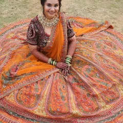 Another view of this magnificent bridal lehenga. The intricate embroidery is complemented by a timeless makeup look, featuring a warm-toned palette and a happy, glowing smile.