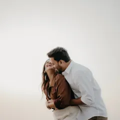 A moment of pure, uninhibited laughter. This candid shot captures a sweet embrace and a joyful laugh, showing the fun and loving dynamic of the couple.