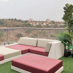 A detail of the Vondom Pixel series furniture on the Project 22 Days terrace. The combination of crisp white frames and deep magenta cushions adds a pop of color to the green artificial turf and natural landscape beyond.