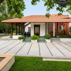 A sprawling traditional home with a long veranda covered by a tiled roof supported by classic pillars. This design creates an expansive, shaded outdoor living space that is both elegant and highly functional.