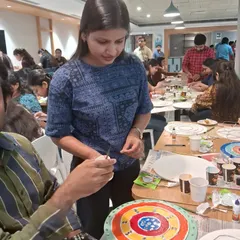 An instructor providing one on one guidance during a busy corporate workshop. We ensure that even in a large group, every participant feels supported in their creative journey.