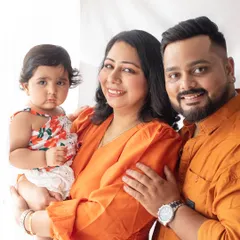 A bright and happy family portrait. The coordinated orange outfits bring so much warmth and energy to this photo, celebrating their daughter's birthday.
