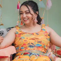 A joyful, laughing shot of the bride at her Mehendi. The vibrant yellow outfit is perfectly complemented by the all-pink makeup look, creating a fun and festive style.