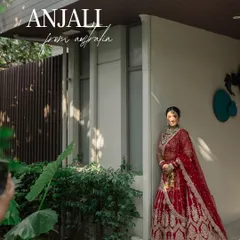 A full-length portrait of Anjali from Australia, looking stunning in her red lehenga. This shot captures her grace and the beauty of her bridal attire in a natural, elegant setting.