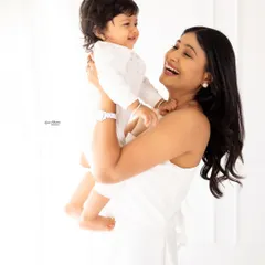 A mother's joyful laugh as she lifts her baby high. The bright, airy feel of this photo perfectly matches the happy emotion of the moment.