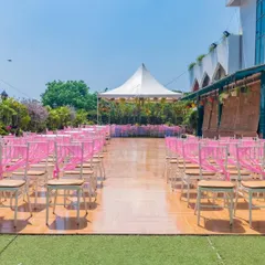 A wide shot of our Terrace Garden set up for a daytime event. The combination of the wooden floor, green turf, and pink chair sashes creates a fresh and inviting atmosphere.