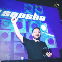Holding my headphones, ready for the next transition. The vibrant blue lighting and my logo on the screen create a futuristic, high-energy atmosphere.