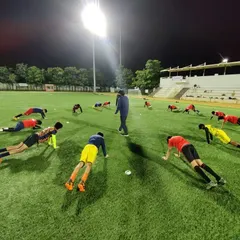 A coach leads a group of young players through a planking exercise. Core strength is fundamental to a player's stability and power, and it's a key component of our fitness training.