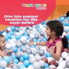 Two children enjoying our massive ball pit. It's the perfect place to dive into fun, especially during school vacations.
