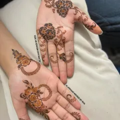 Two different but complementary minimalist designs. One hand has a shaded floral vine, while the other features a modern floral hoop pattern.