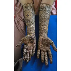 This design shows a classic combination of floral elements on the fingers and paisleys covering the arms, a hallmark of Indian bridal mehendi.