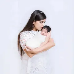 A mother's gentle love captured as she holds her sleeping newborn close. A simple, powerful portrait of the bond between mother and child.