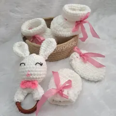 The full bunny-themed gift set, featuring a bunny rattle, soft booties, and matching mittens, all in white with delicate pink ribbon accents.