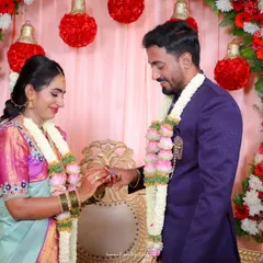 The key moment of the ring exchange during an engagement ceremony, capturing the bride placing the ring on the groom's finger.